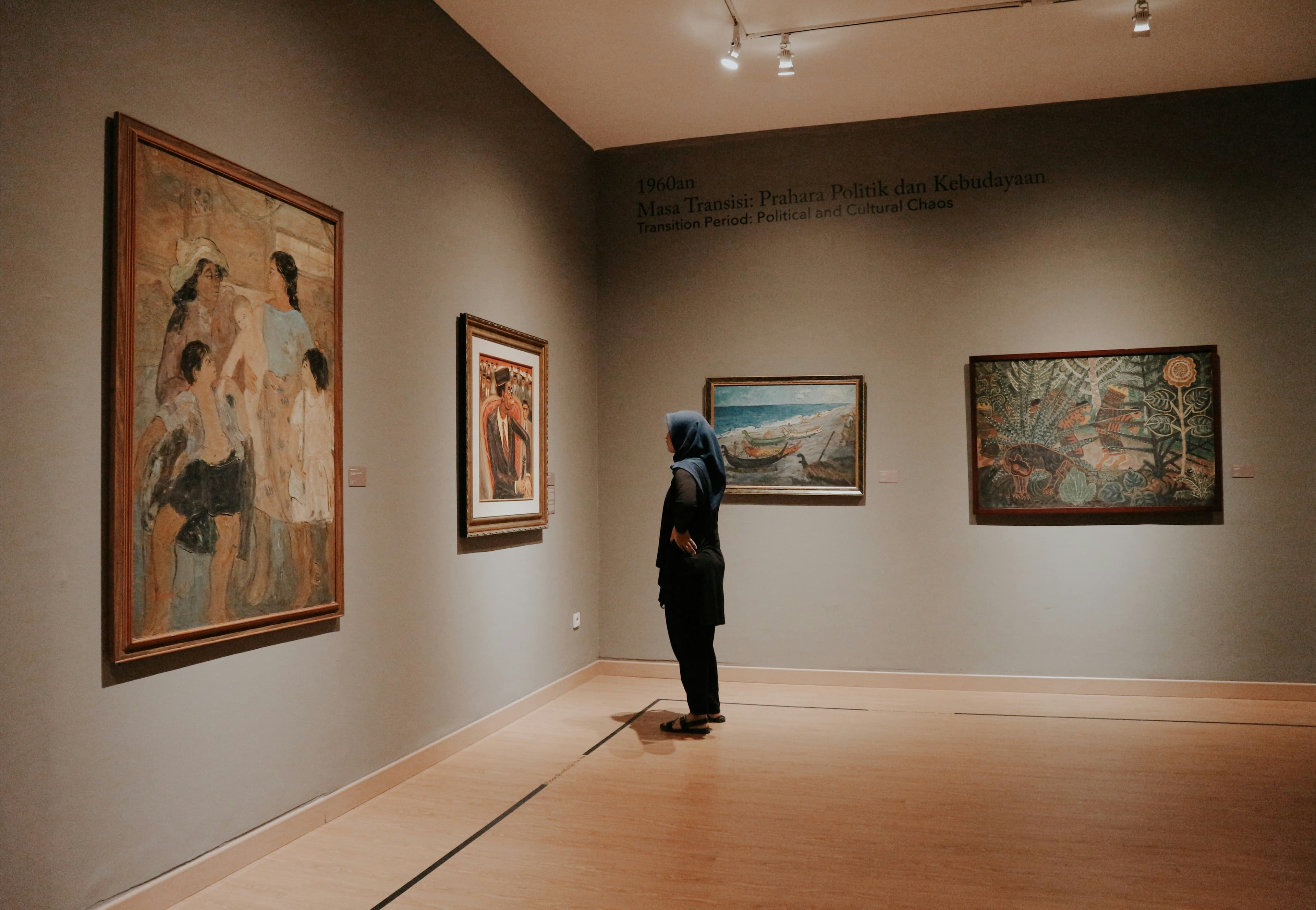 Visitor looking at paintings in a contemporary gallery